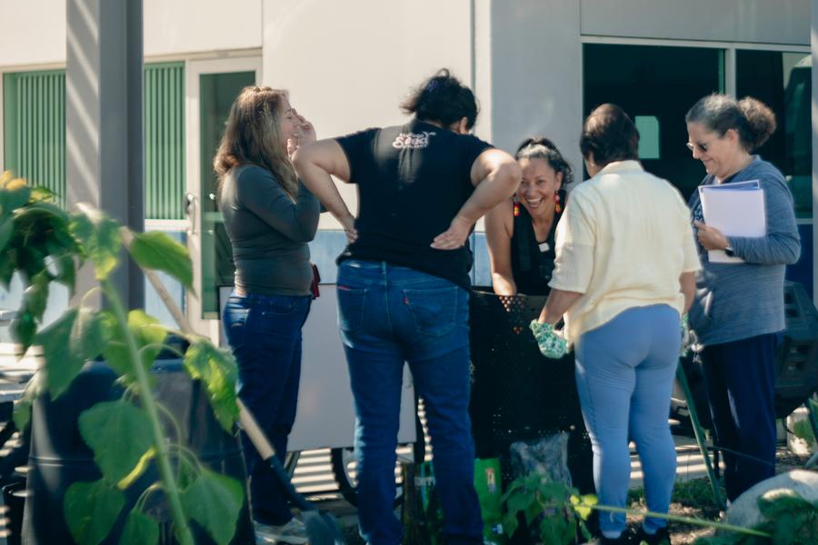 Volunteers share a laugh during a hands-on composting demonstration.
