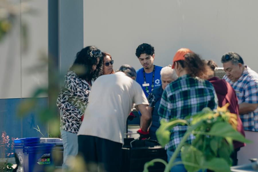 Volunteers share a laugh during a hands-on composting demonstration.