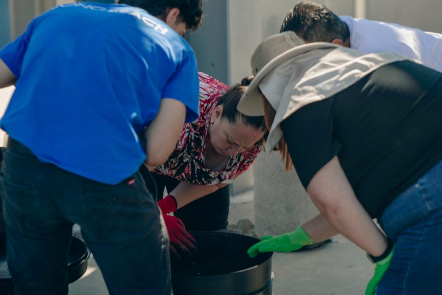 Participants gather around the compost bin to see it in action.