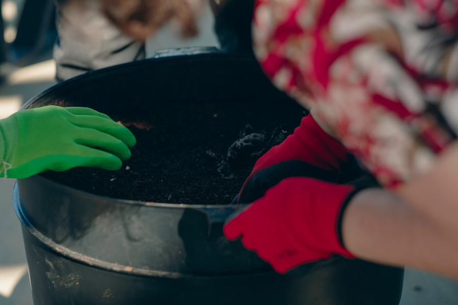 A volunteer demonstrates proper composting technique.