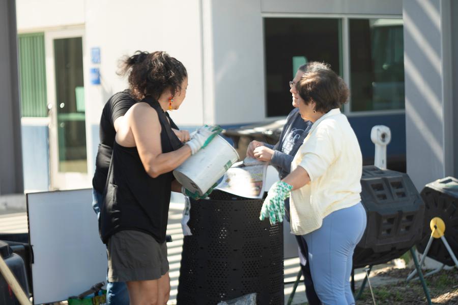 Participants pass along flowers and greens for the compost pile.