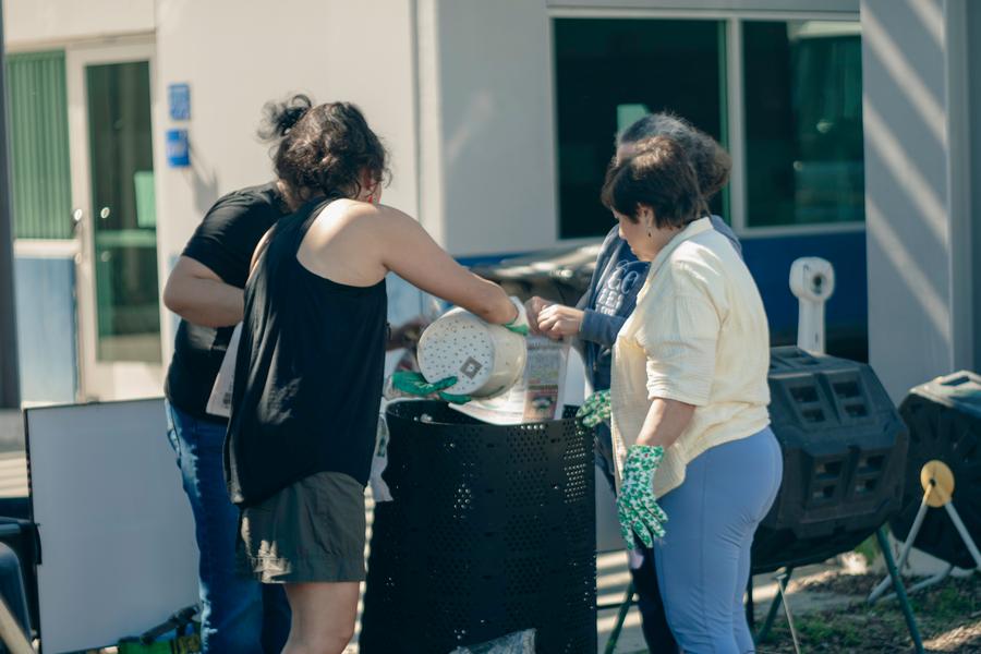 Volunteers share a laugh during a hands-on composting demonstration.