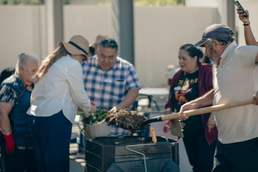 Participants gather around the compost bin to see it in action.