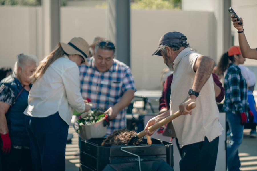 A volunteer demonstrates proper composting technique.