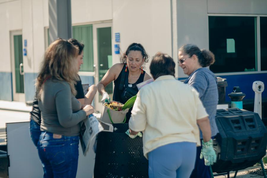A participant digs into a fresh batch of compost.