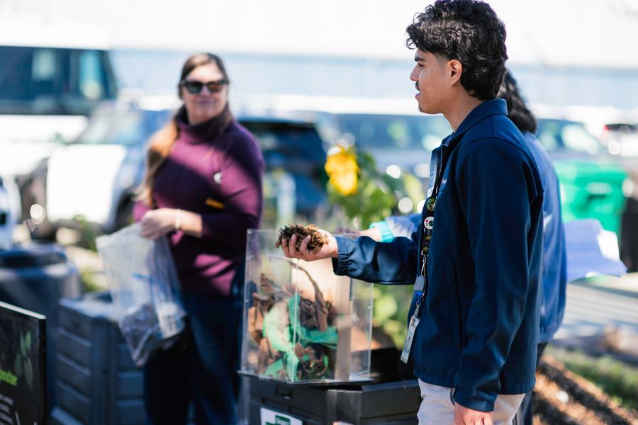 A CRA facilitator holds fresh compost during a hands-on demonstration.