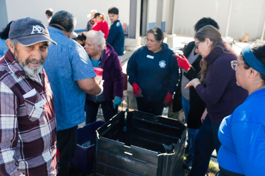 The group examines a home composting bin together.
