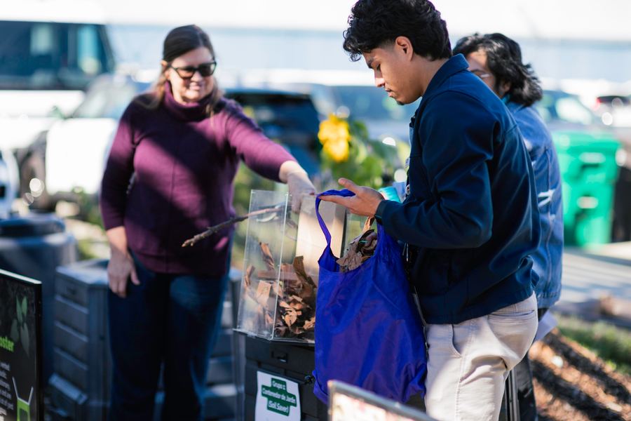 A facilitator hands over compost materials to a participant.